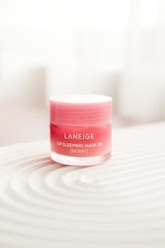 Close-up of Laneige Lip Sleeping Mask EX in berry flavor on textured surface. Product photography.